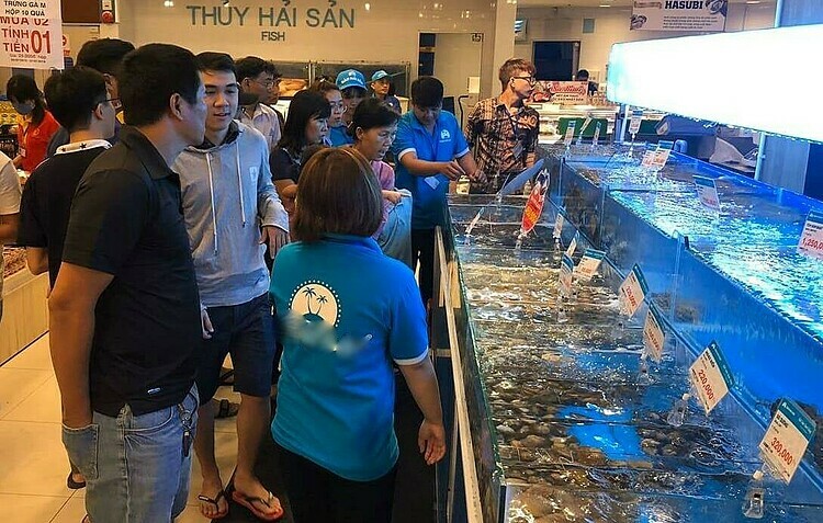 Người mua tôm hùm tại cửa hàng hải sản ở TP HCM. Ảnh: PV.